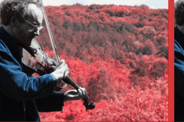 Violoniste sur fond de colline arborée, à travers un filtre rouge