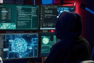 un hacker devant 4 écrans