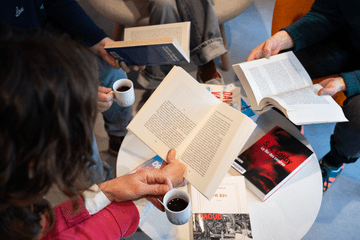 Des personnes tiennent des livres ouverts et des tasses à café