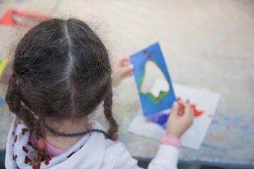 Petite fille de dos en train de réaliser un atelier de pratique artistique