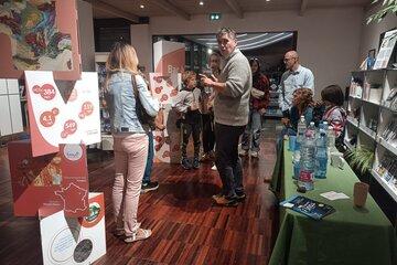Stand avec quelques participants. A droite une table avec des bouteilles d'eau.