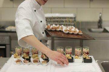 Un cuisinier pose des verrines sur un plateau