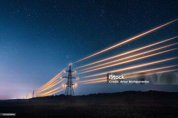  Tours de transmission d’électricité avec des fils orange incandescents contre le ciel nocturne.