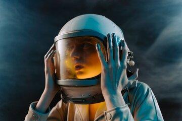  femme spationaute tenant son casque entre ses mains