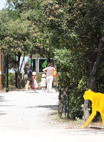 Vu d'une allée du parc De Lunaret, avec une silhouette de guépard qui invite à la promenade 