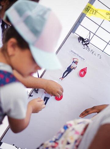 enfants face à un tableau d'enquête