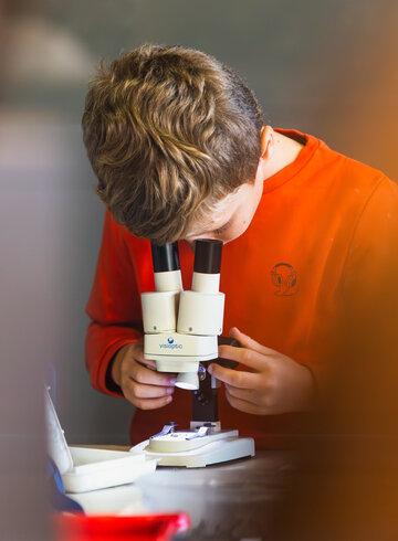 Un garçon teste un microscope